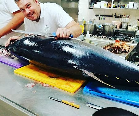 Chefkoch und frisch gefangener Thunfisch Chefkoch und frisch gefangener Thunfisch